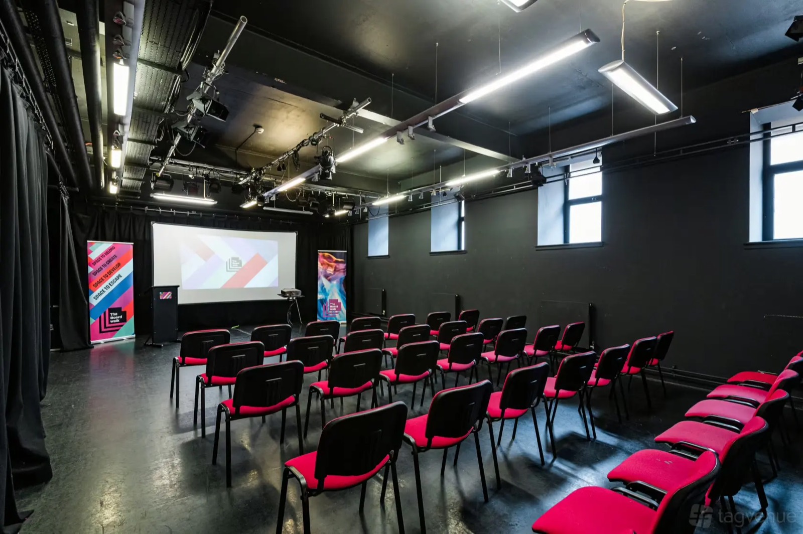The Black Studio screening room with rows of red seats